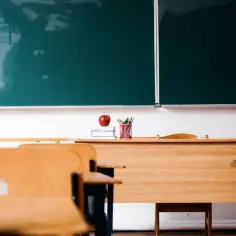 Pusta klasa z ławkami i zieloną tablicą. Na biurku jabłko i ołówki. Czy ocene roczna mozna zmienic?