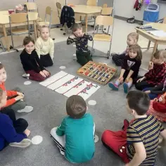Dzieci w oddziale przedszkolnym w szkole podstawowej uczą się liter. Wymagania edukacyjne są spełniane podczas zabawy.