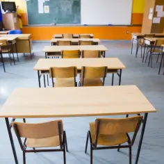 Puste ławki i krzesła w sali lekcyjnej czekają na uczniów. Obowiązek nauki wkrótce wypełni te pomieszczenia.
