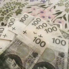Stos banknotów 100 zł. Może to być związane z przeliczeniem emerytury nauczycielskiej na powszechną.