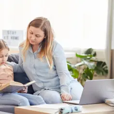 Mama pomaga córce w nauce, przygotowując usprawiedliwienie nieobecności w szkole.