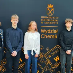 Pięcioro młodych ludzi, w tym jeden laureat, pozuje przed ścianką z logo Wydziału Chemii UJ.