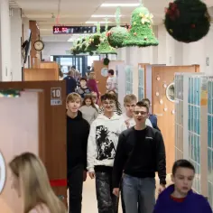 Uczniowie idą szkolnym korytarzem, ozdobionym świątecznymi dekoracjami. Czy w piątek jest wolne od szkoły?