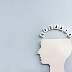 Biały profil głowy z literami tworzącymi słowo "APHASIA" nad nim. Symbolizuje to afazję mieszaną, trudności w komunikacji.