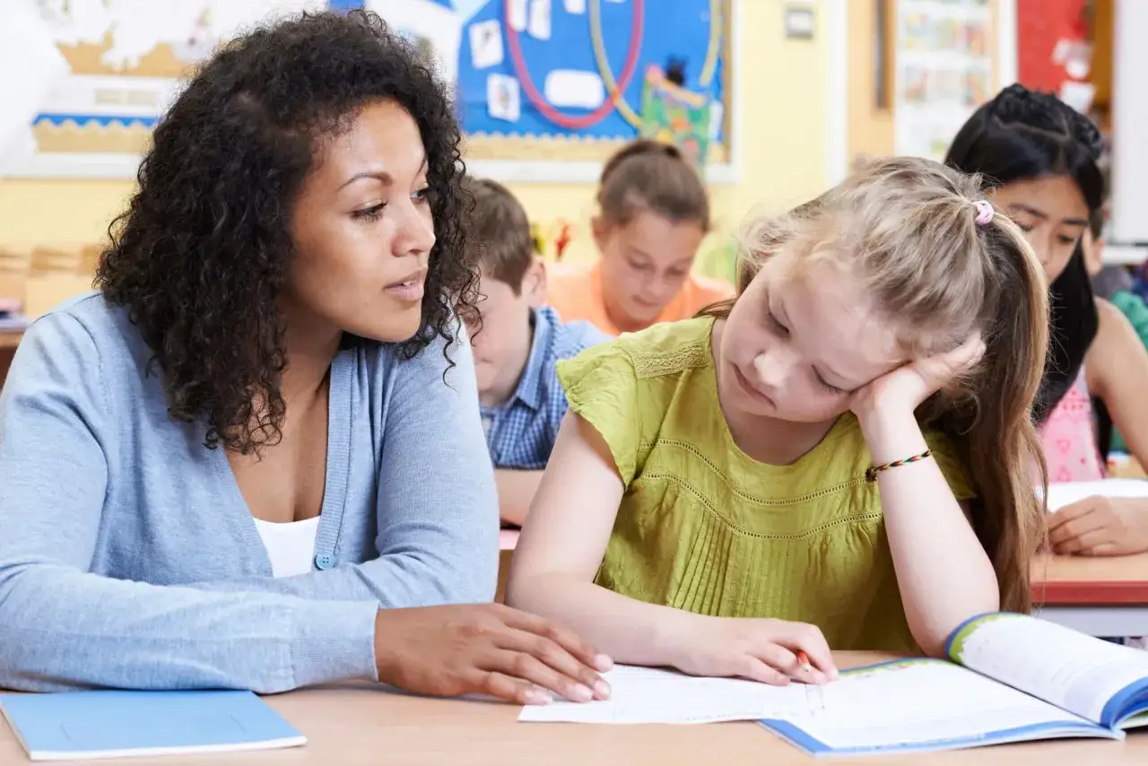 Nauczycielka wspiera uczennicę podczas lekcji. Edukacja zdrowotna program nauczania w praktyce.
