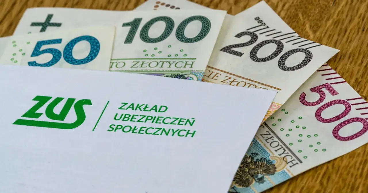 Koperta ZUS i polskie banknoty 50, 100, 200, 500 zł. Symbolizuje odprawę dla nauczyciela przechodzącego na świadczenie kompensacyjne.
